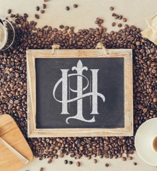 The Hook & Ladder logo on a chalkboard with coffee beans underneath